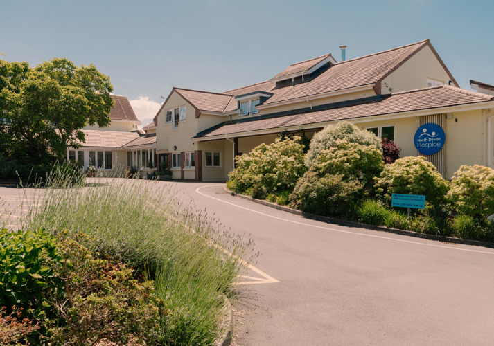 Outside the front of the North Devon Hospice building, in the sunshine with plants in the foreground
